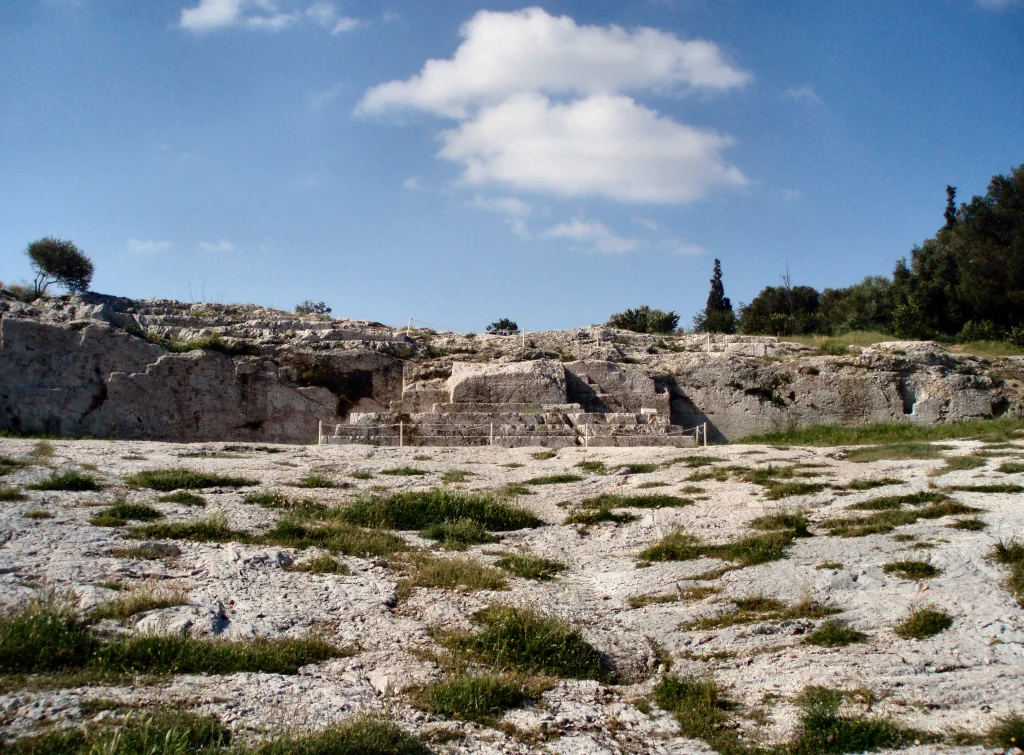 La democracia ateniense: una mirada a la cuna de la participación ciudadana en Grecia Antigua 5 Vista de la colina de la Pnyx en Atenas, con el terreno de reunión al aire libre visible en relación con el paisaje urbano.